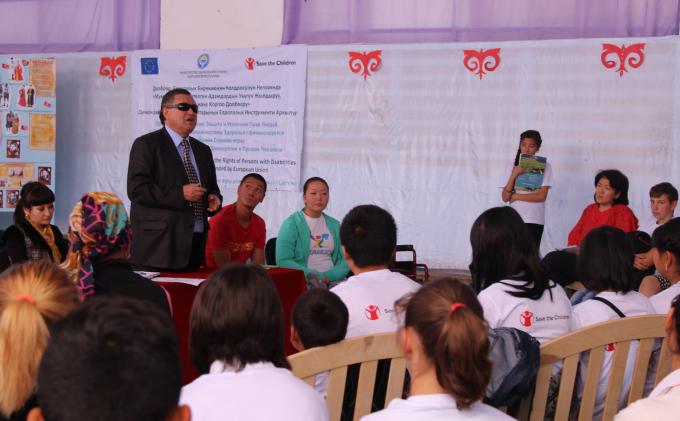 Kalyk (62), president of the Kyrgyz Association of Blind and Deaf, tells school children about his story during an information campaign organized by Save the Children