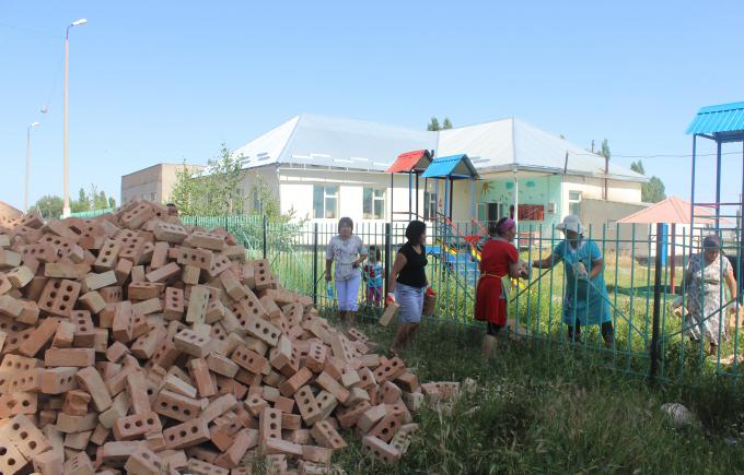 Parents and ECD teachers are working together to transport bricks in Syrduu Balalyk ECD center in Sokuluk District. These materials will be used in their small community project to accommodate new groups. The title of the small-scale project is "Classroom and bedroom extension for the new groups."