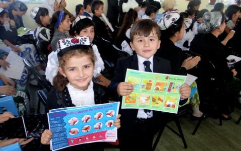 Children display educational materials produced by SHN project